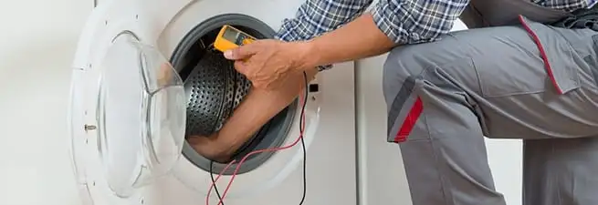 Dryer repair technician inspecting and repairing a clothes dryer in West Palm Beach, FL