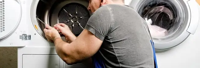 Dryer repair technician fixing a clothes dryer drum in West Palm Beach, FL