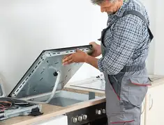 Appliance repair technician installing a built-in cooktop in West Palm Beach, FL