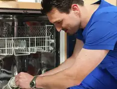 Dishwasher repair technician inspecting and servicing an open dishwasher in West Palm Beach, FL