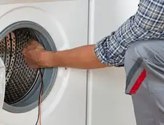 Dryer repair technician diagnosing and servicing a clothes dryer in West Palm Beach, FL