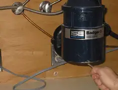 Garbage disposal repair technician tightening the mounting ring under a sink in West Palm Beach, FL