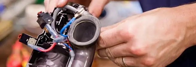 Vacuum repair technician reconnecting wiring and components in West Palm Beach, FL