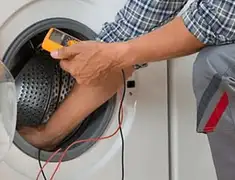 Washing machine repair technician testing a front-load washer with diagnostic tools in West Palm Beach, FL