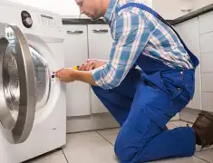 Washing machine repair technician servicing a front-load washer in West Palm Beach, FL