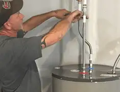 Water heater repair technician tightening supply line connections in West Palm Beach, FL